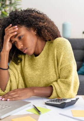 Stressed black woman working at home alone